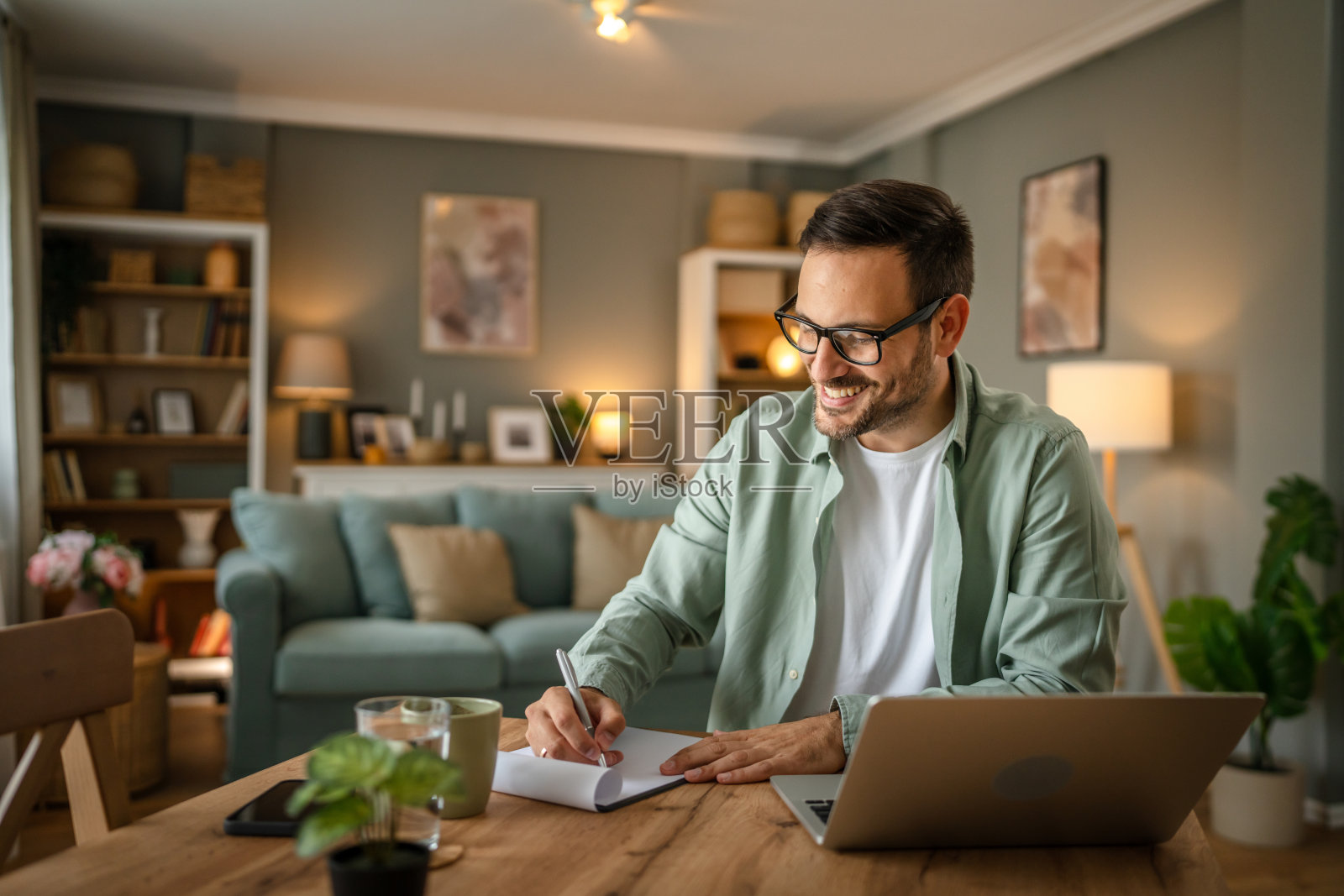 一名成年白人男性在家中愉快地微笑着使用笔记本电脑照片摄影图片