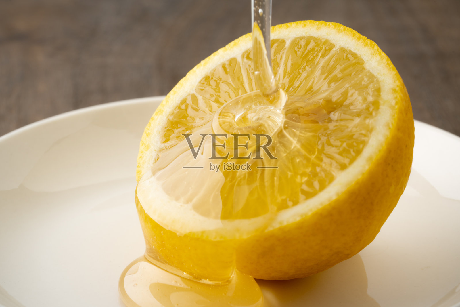 柠檬上淋上蜂蜜的特写镜头照片摄影图片