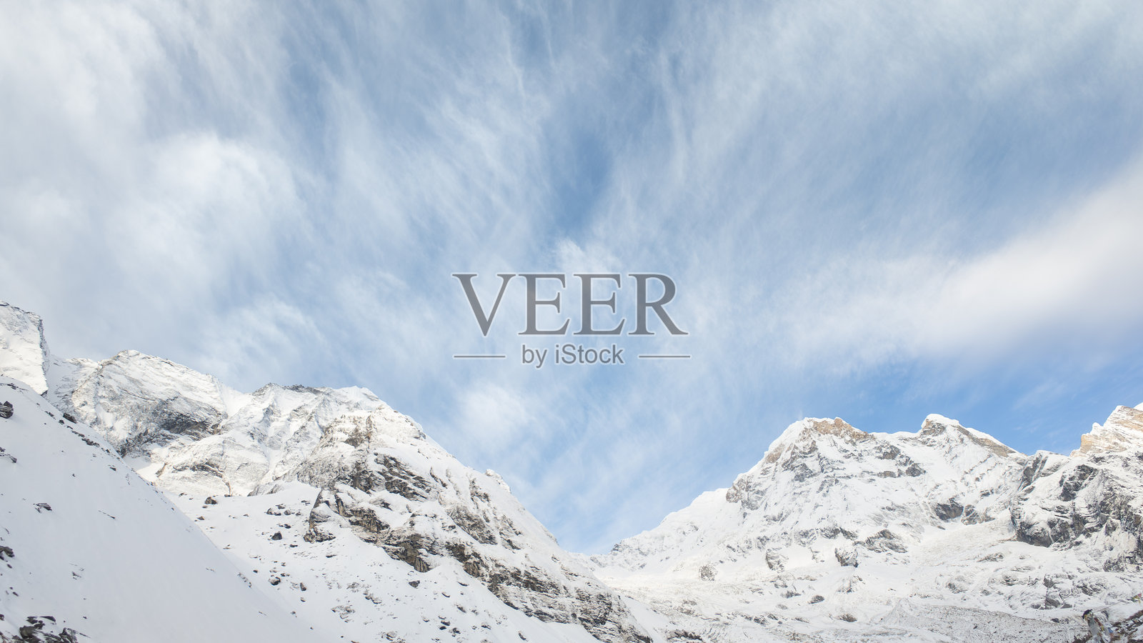 安娜普尔纳大本营（ABC）早晨可见的雪山喜马拉雅峰，背景是蓝天和白云。岩石山脉和雪白悬崖。照片摄影图片