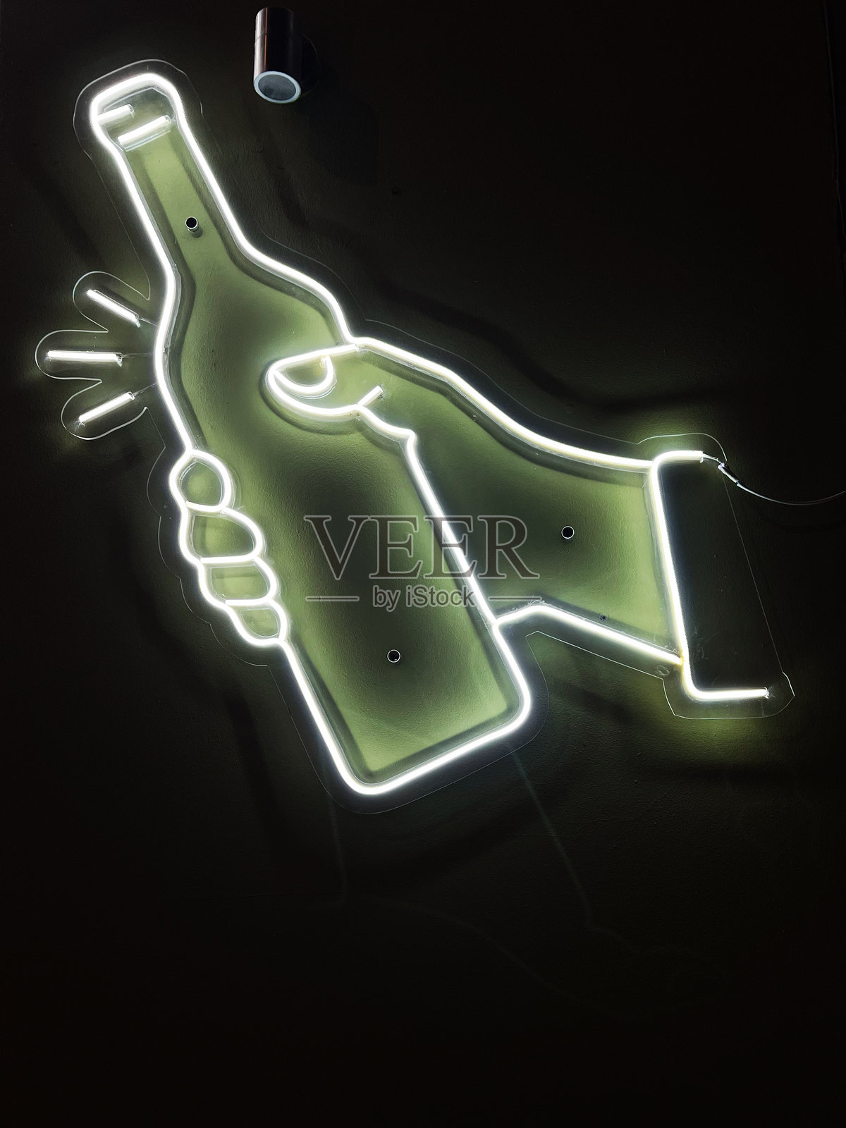 明亮的霓虹灯标志，描绘了一只手握着瓶子，背景为黑暗色调照片摄影图片
