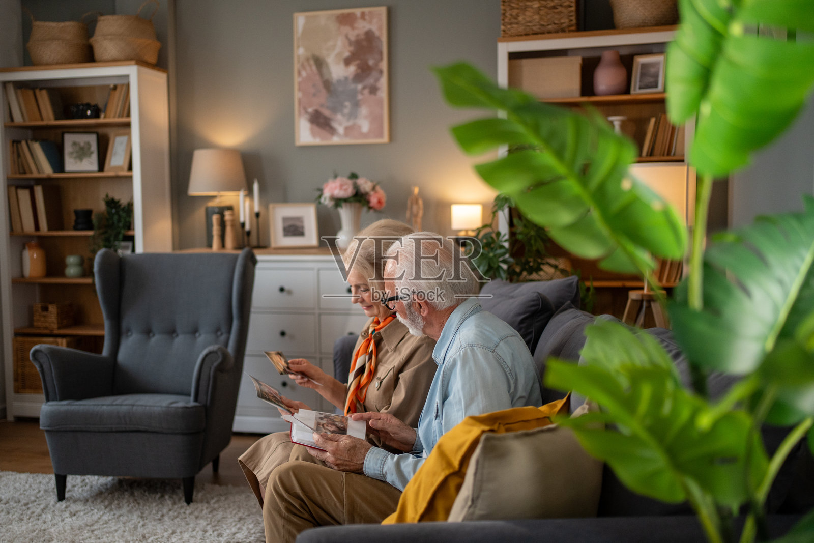 一对老年夫妇坐在沙发上一起翻看相册照片摄影图片