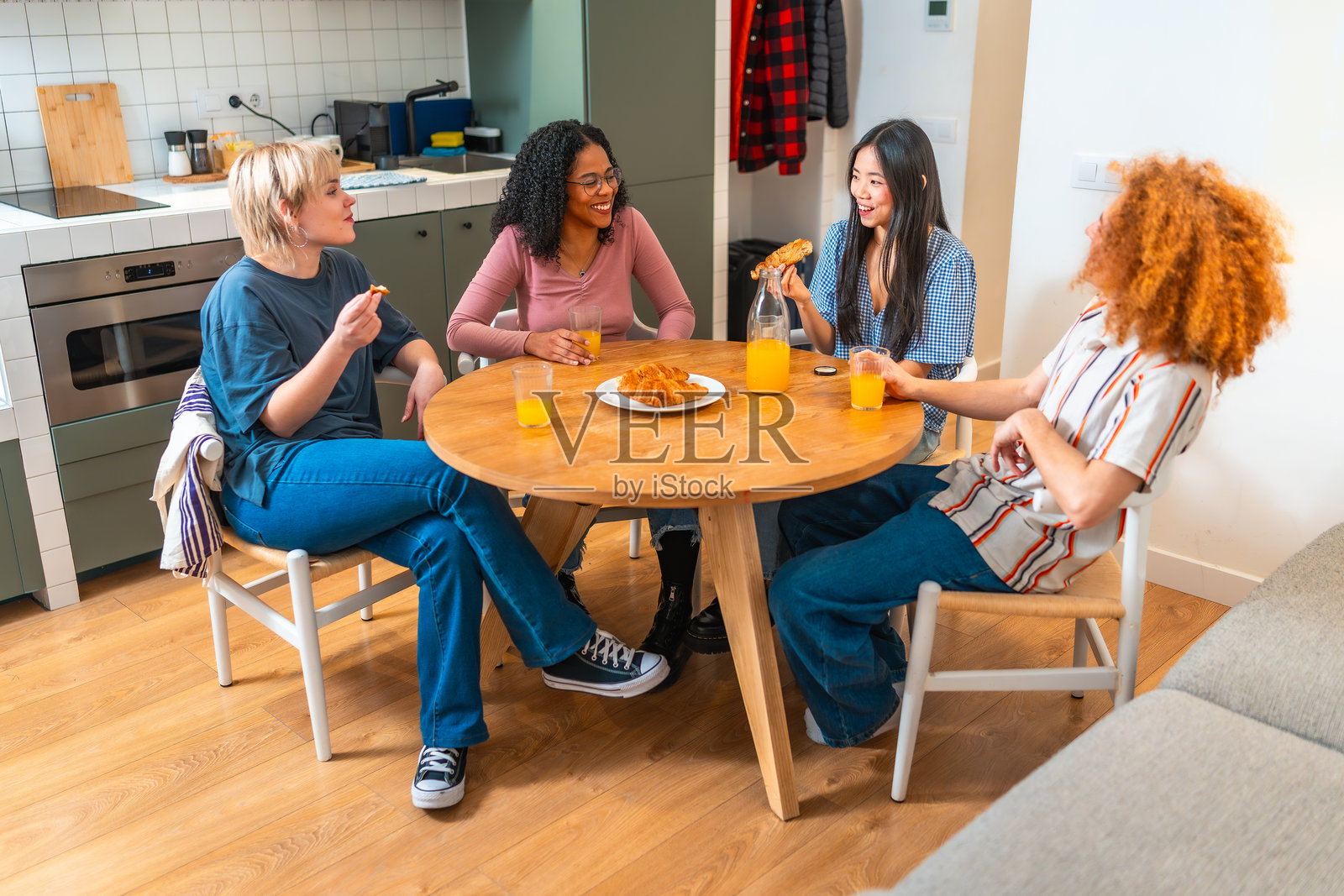 四位年轻女性在家里一起吃早餐并聊天照片摄影图片