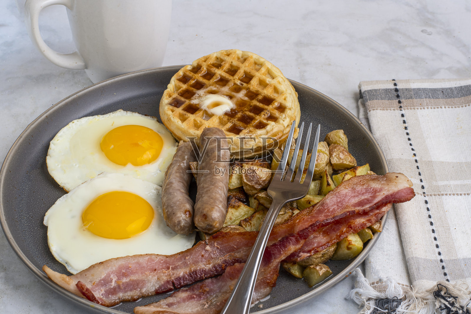 煎蛋配华夫饼，上面淋上融化的黄油和糖浆照片摄影图片
