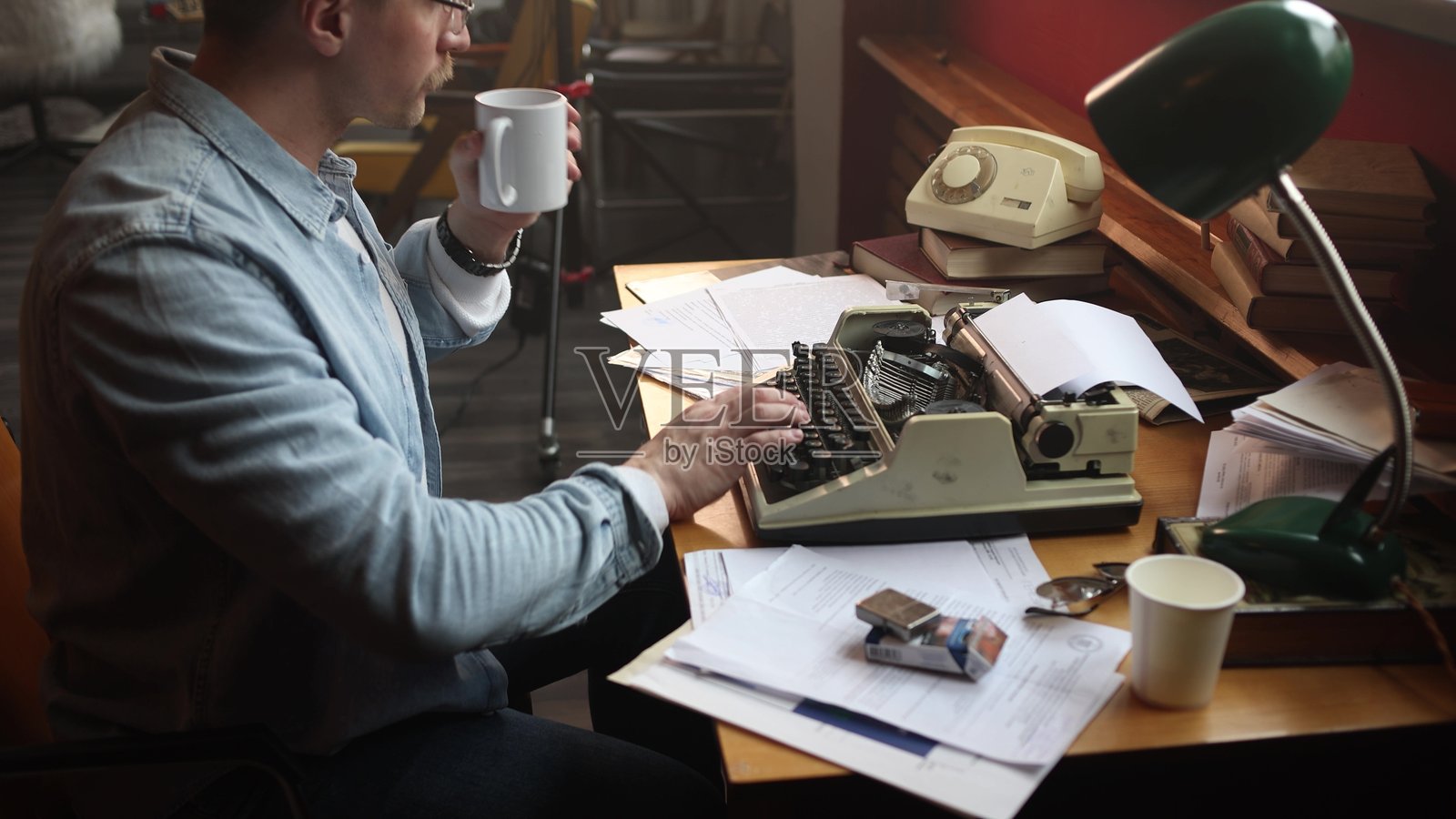 一名男性记者专注地抽烟并写作他的文章。照片摄影图片