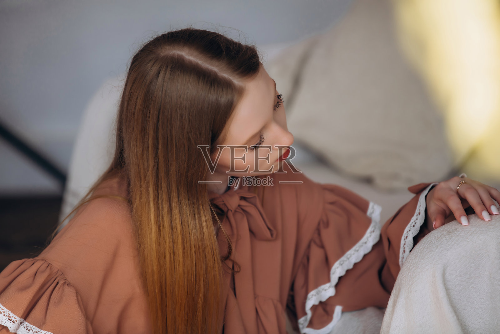 美丽的金发模特，年轻女孩，青少年，在室内沙发旁的蕾丝裙工作室中照片摄影图片