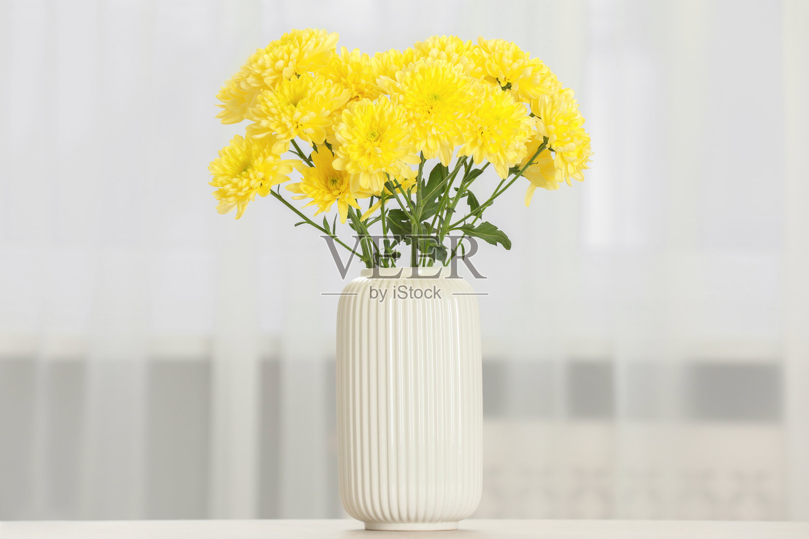 家中桌子上的美丽黄色花朵插在花瓶里照片摄影图片