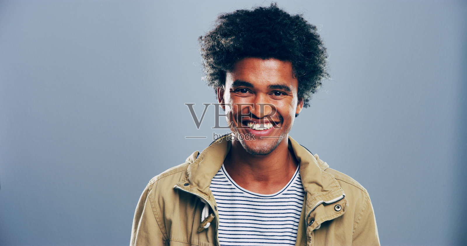 快乐的学生与微笑的男性肖像，背景为灰色，适用于奖学金、注册和大学申请。模拟空间、工作室以及对教育、大学和学校感到兴奋的人。照片摄影图片