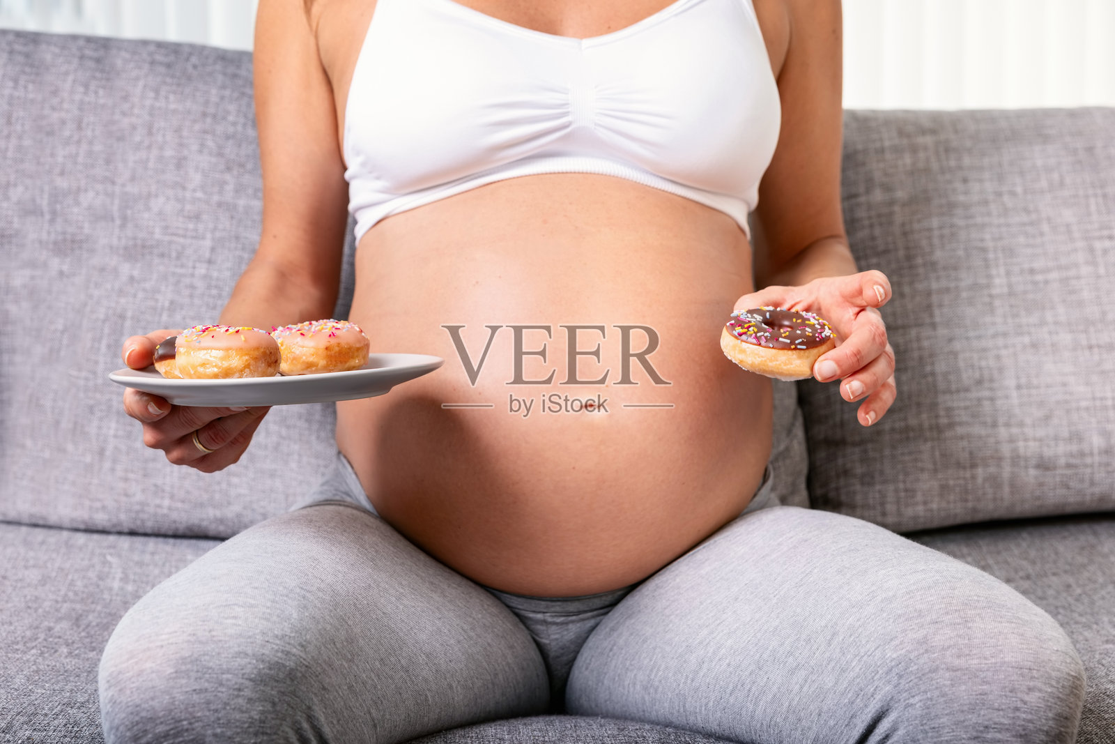孕妇近距离享用甜甜圈照片摄影图片