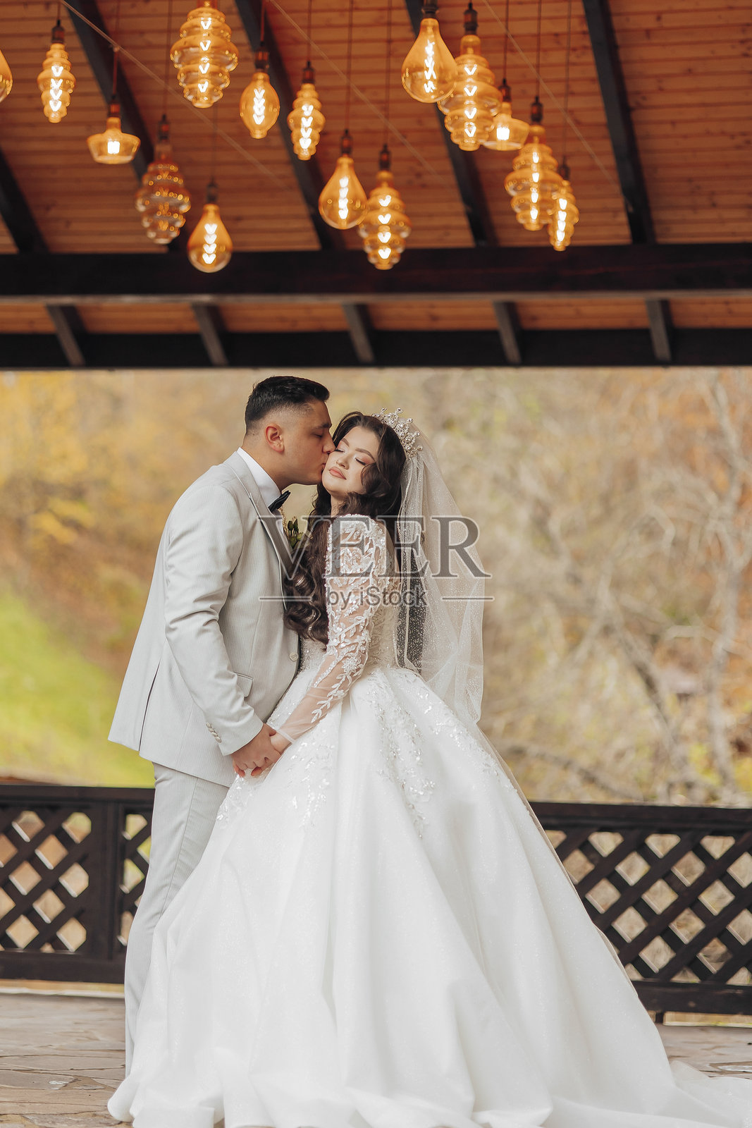 新郎新娘在桥上亲吻彼此照片摄影图片