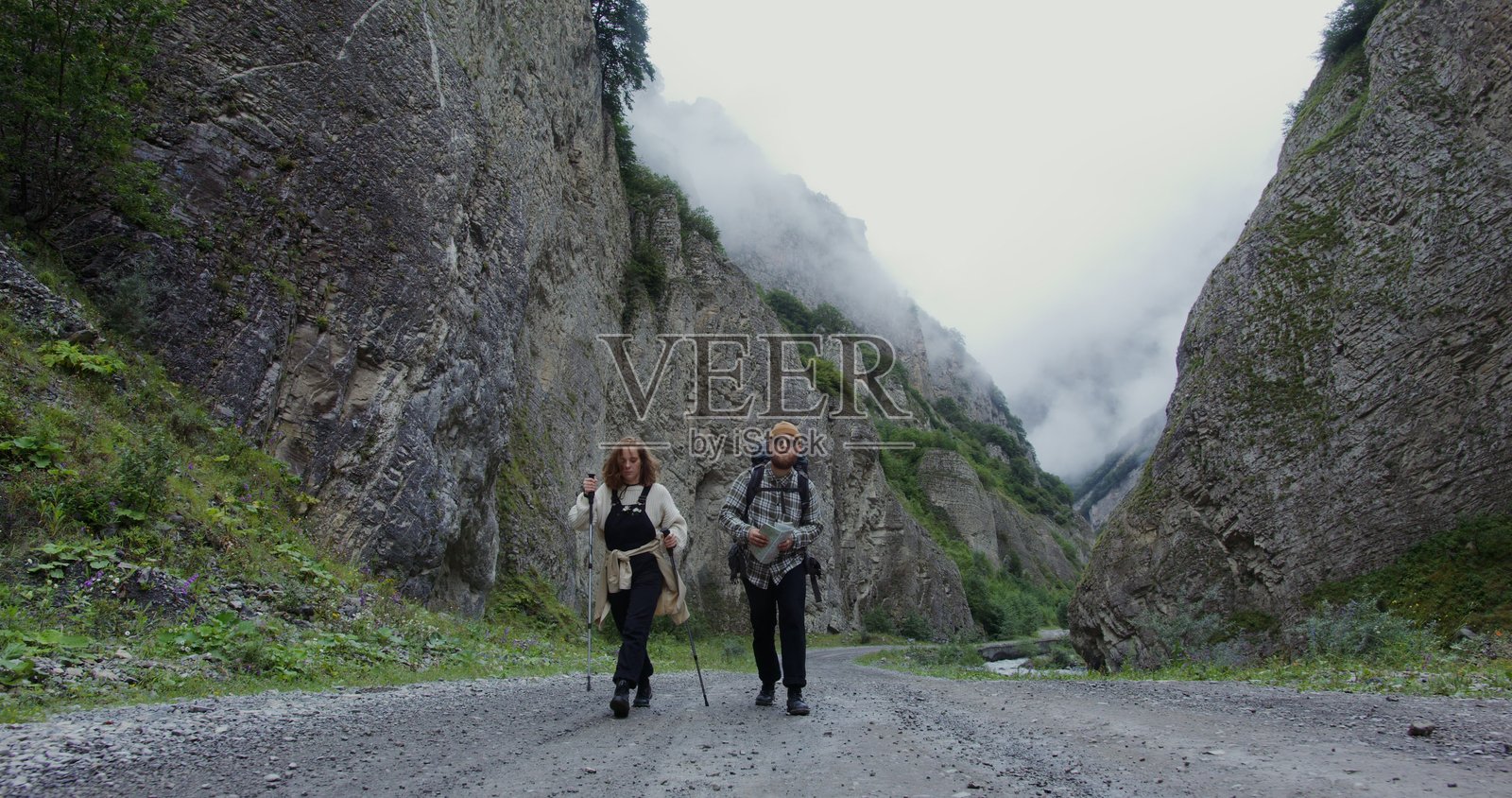 俄罗斯，喀山。年轻的情侣游客在岩石间的道路上漫步。照片摄影图片