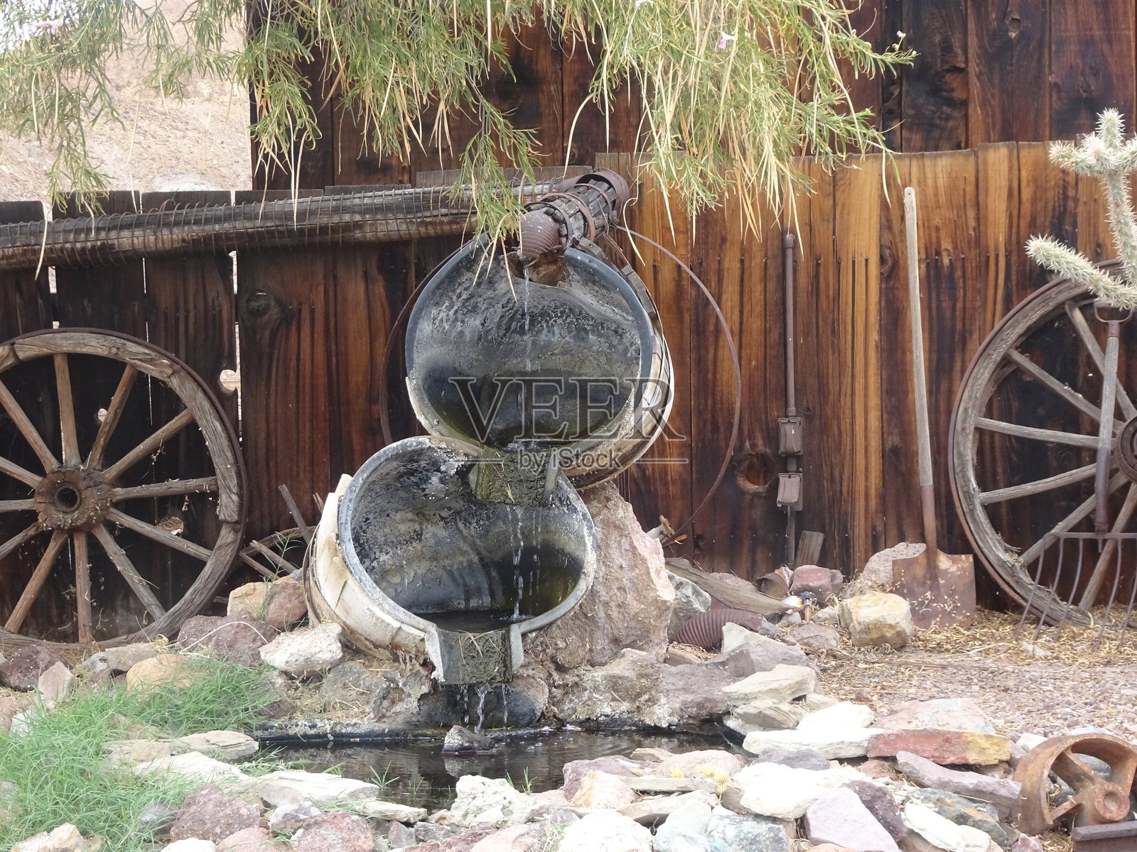 木桶、水泉、木轮、鹅卵石和树叶覆盖的木材照片摄影图片