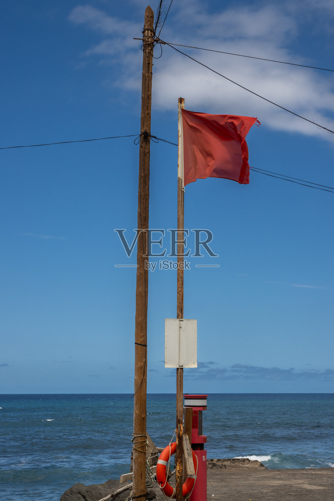 西班牙大加那利岛海滩上的红旗照片摄影图片