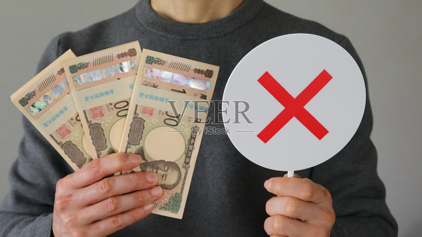 一个人手持一叠钞票和一个叉号标记照片摄影图片