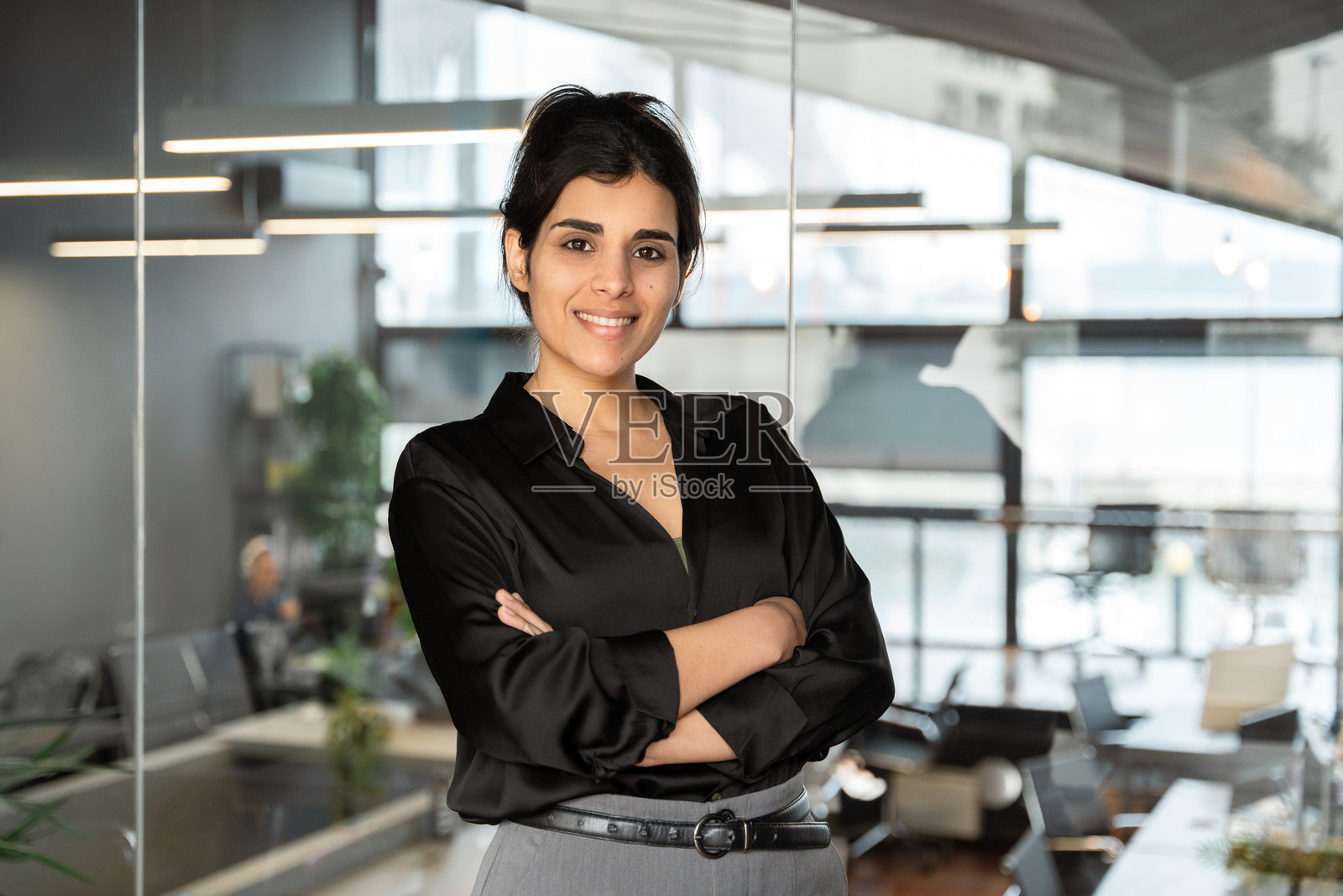 自信的拉丁裔女性专业经理在现代办公室工作。年轻的中东印度或阿拉伯女性高管CEO正看着镜头。照片摄影图片