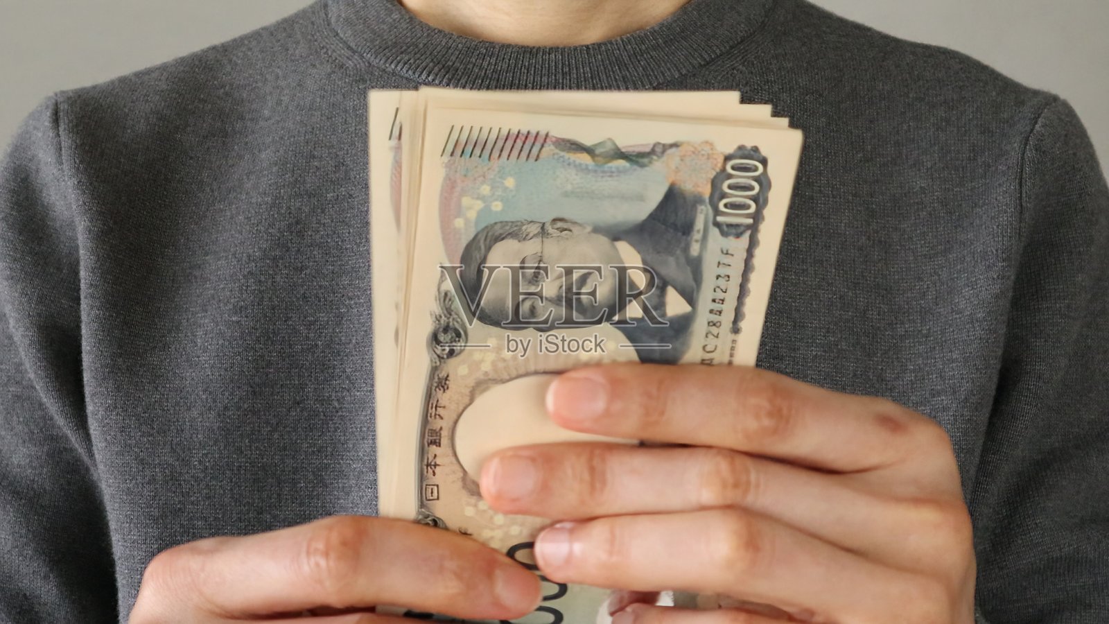 手持日本新1000日元纸币的人照片摄影图片