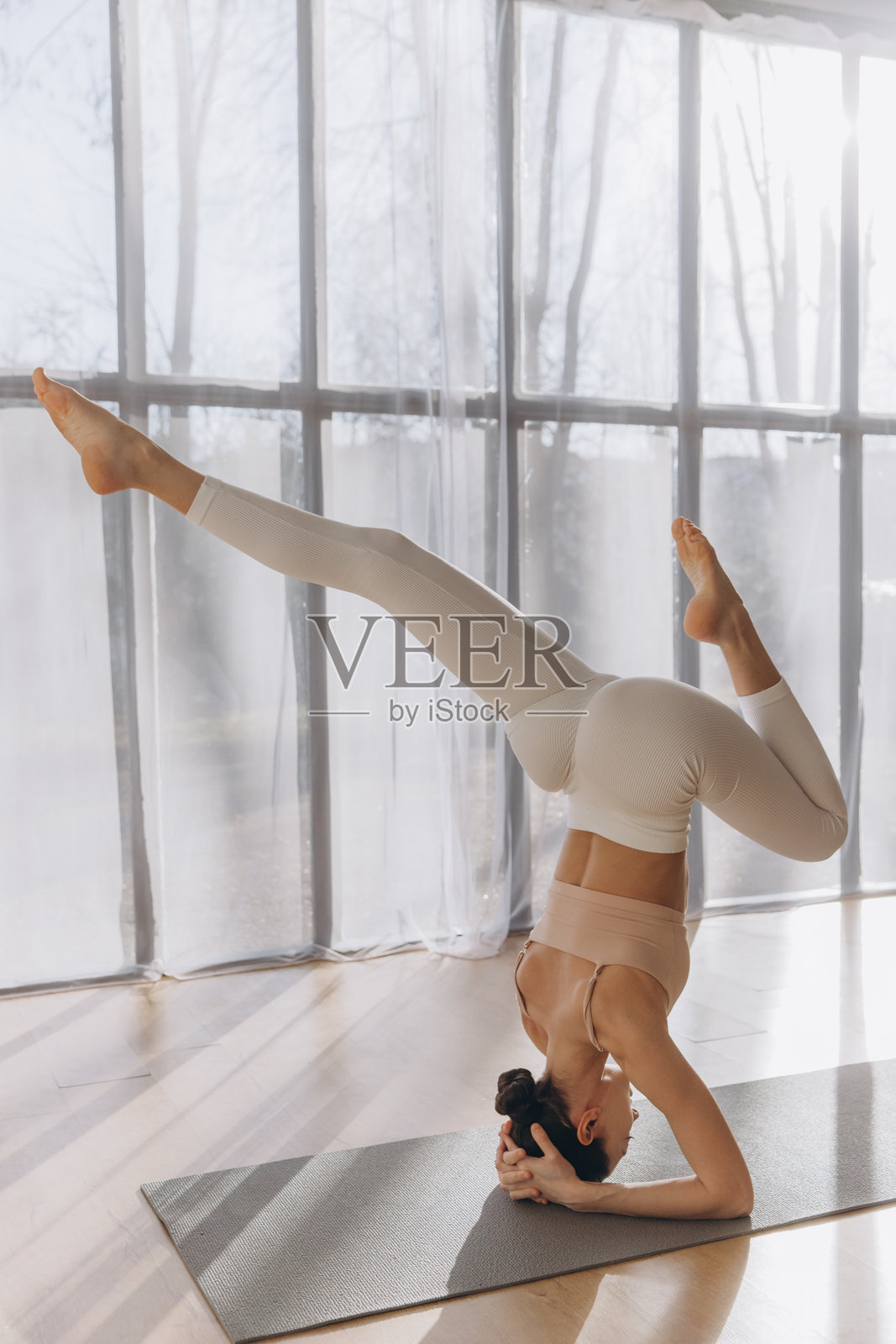 年轻女性在家练习头倒立瑜伽姿势照片摄影图片