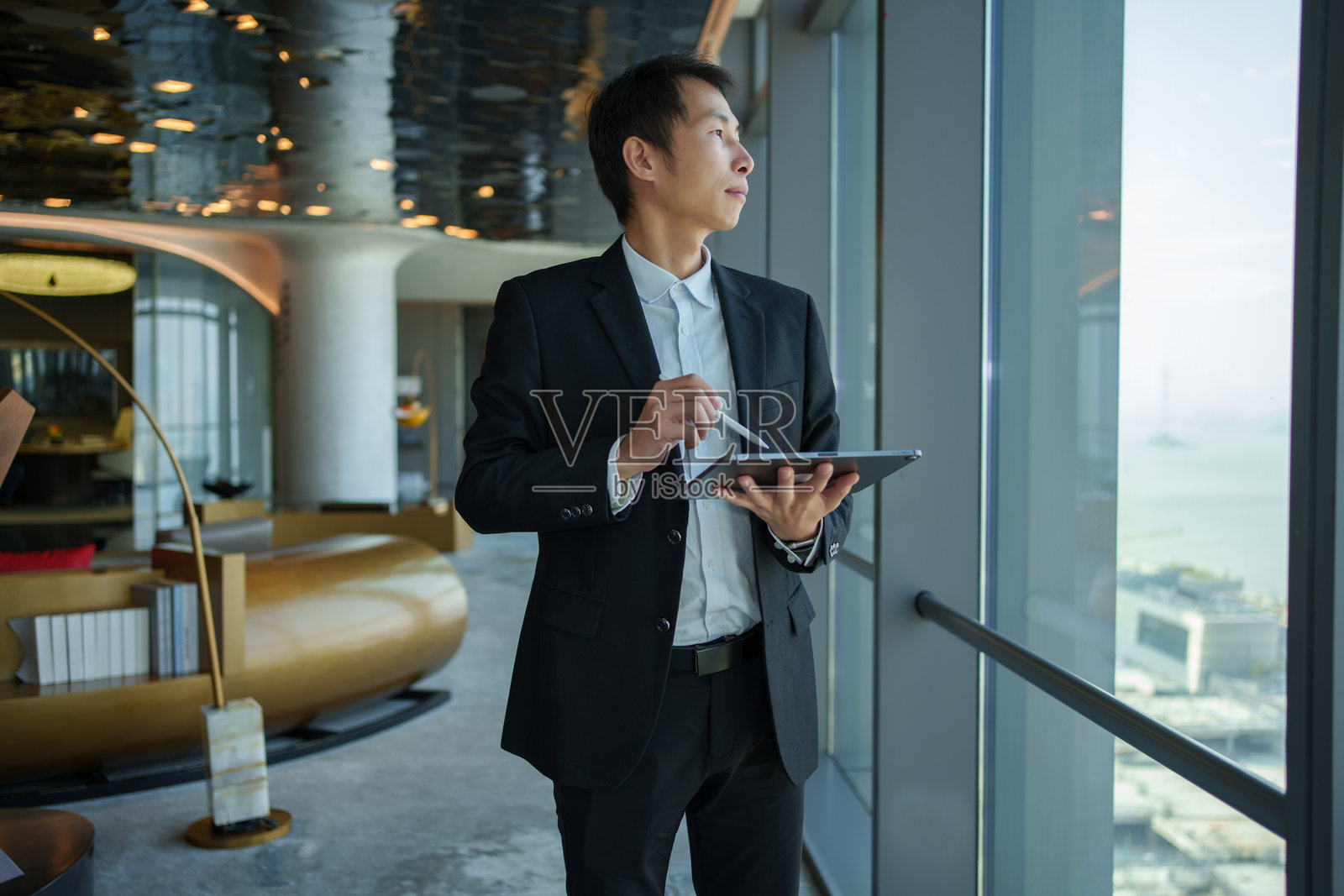 亚洲男性商人手持平板电脑照片摄影图片