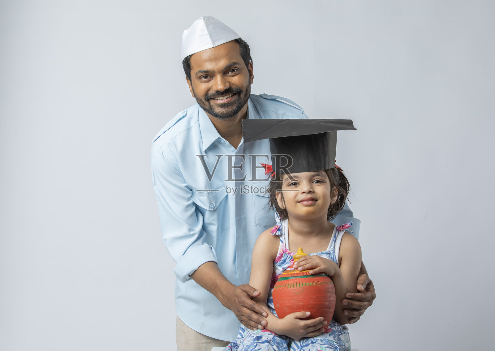 父亲和女儿在白色背景下与储蓄罐一起照片摄影图片