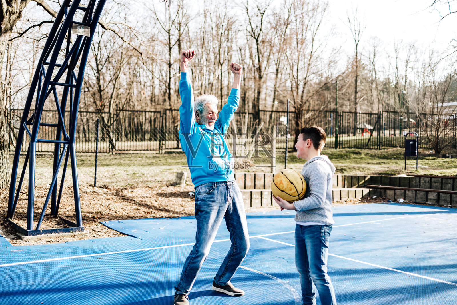祖父和孙子在户外打篮球：庆祝进球照片摄影图片