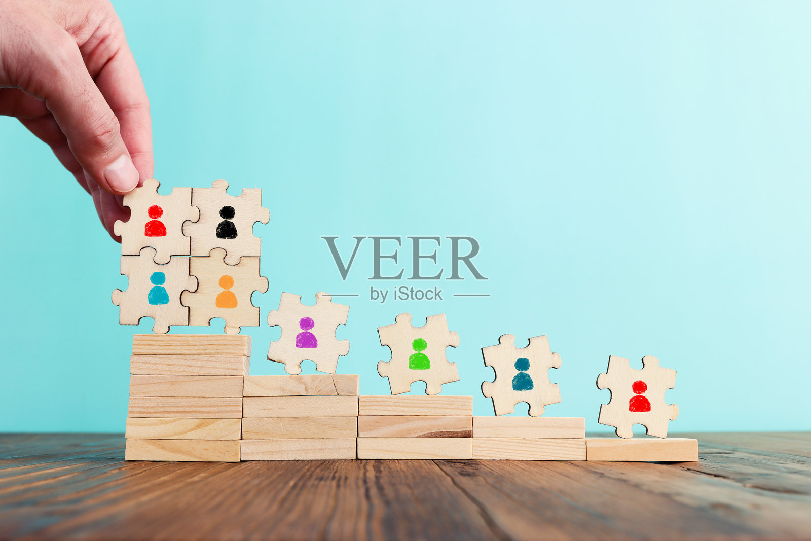 商业图像：拼图与人形图标，背景为柔和色调，体现人力资源与管理概念照片摄影图片