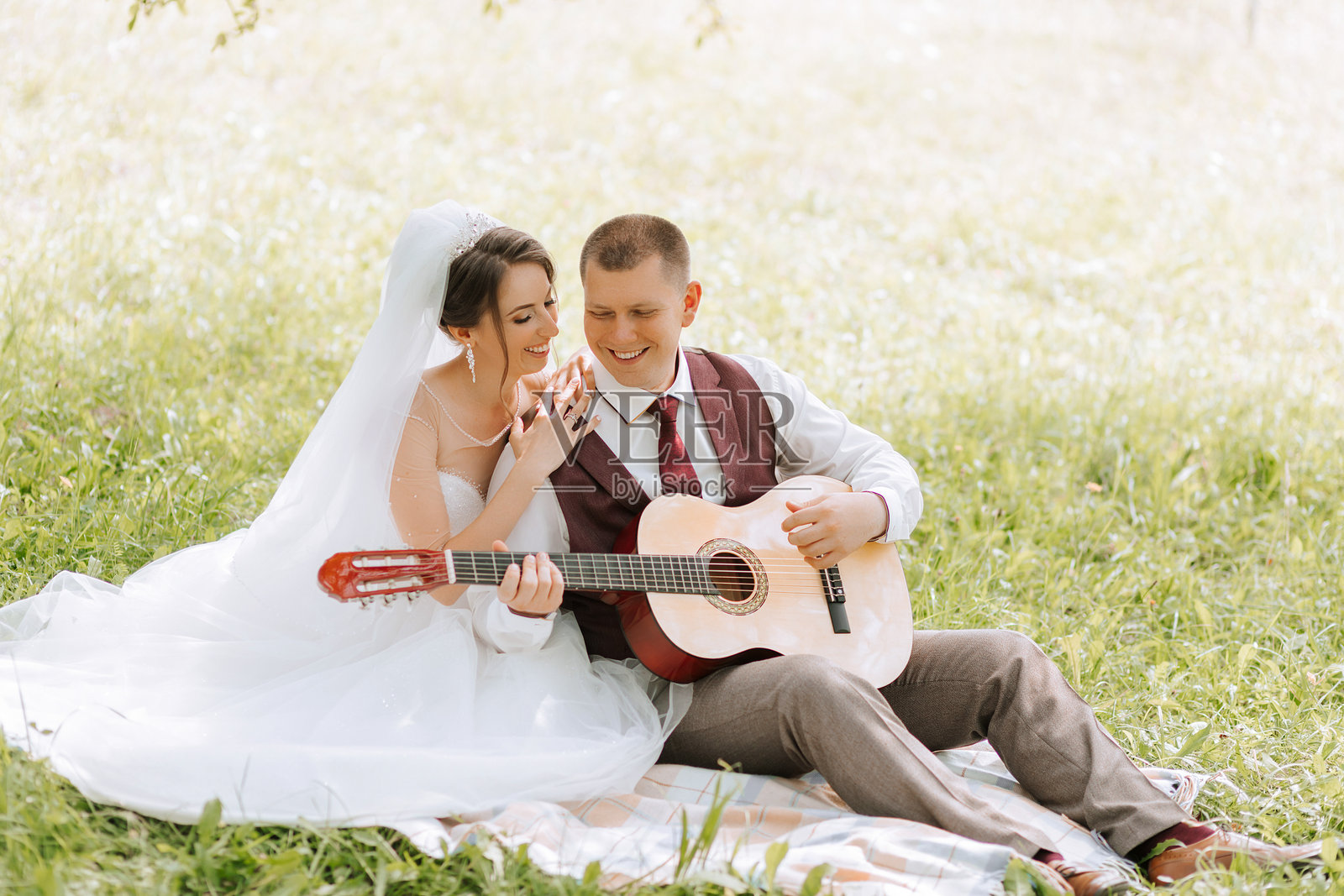 一对情侣坐在草地上的毯子上照片摄影图片