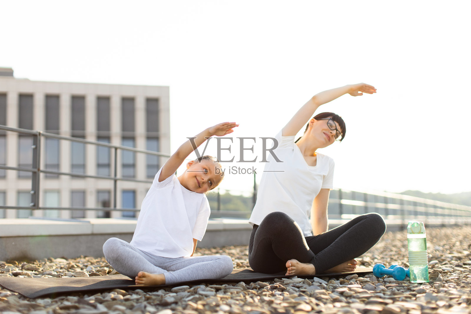 母女在屋顶上练习瑜伽拉伸照片摄影图片