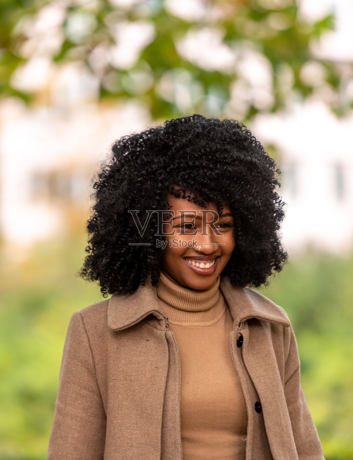 微笑的年轻女性在十月的美丽日子里于公共公园的肖像照片摄影图片