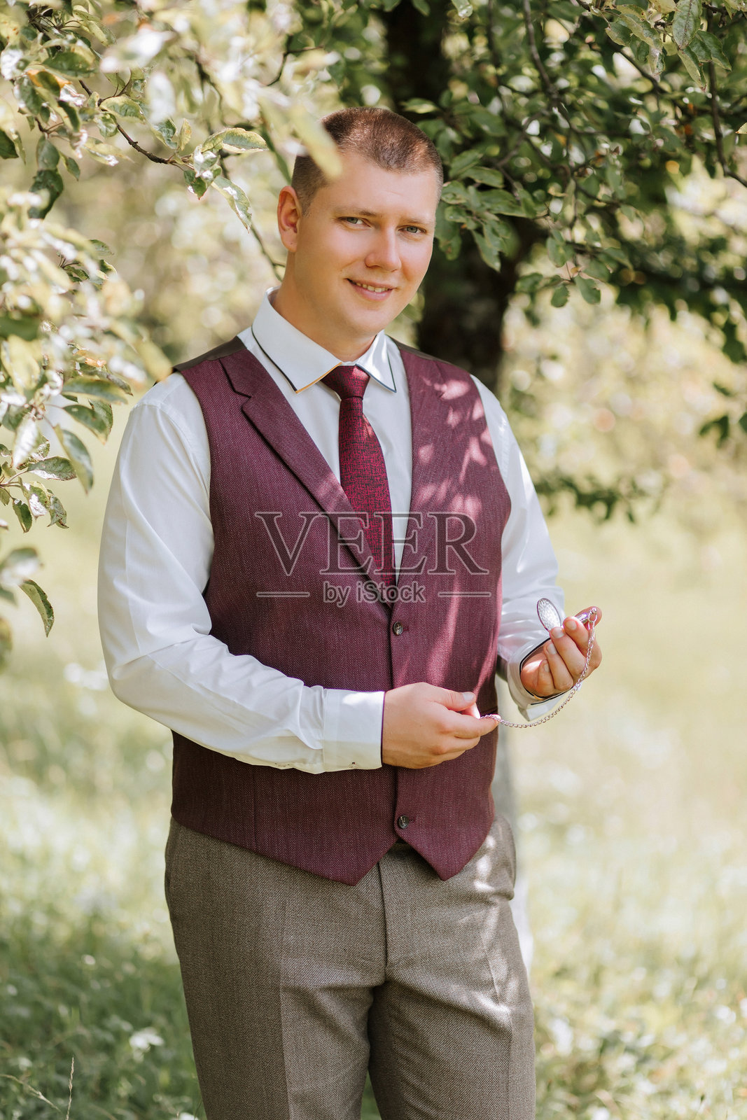 一个穿着红色背心和白色衬衫的男人站在田野里照片摄影图片