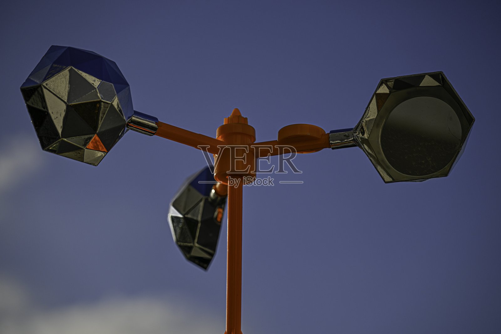 高分辨率特写彩色图像，展示一座覆盖镜子的橙色风车，用于吓跑鸽子 - 以色列照片摄影图片