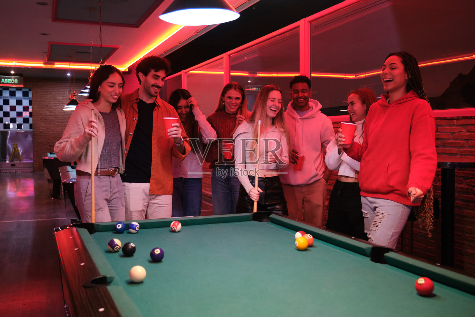 一群朋友在夜总会打台球并享受乐趣照片摄影图片