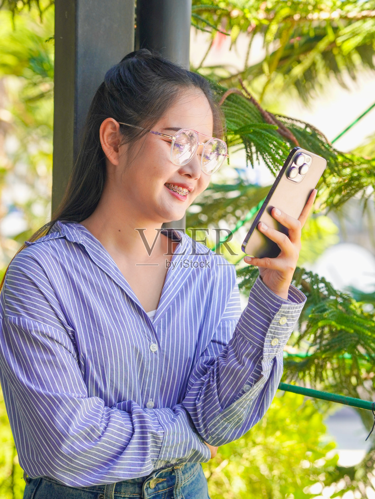 亚洲女性Z世代享受远程工作，使用手机进行在线商业营销，运用科技。照片摄影图片