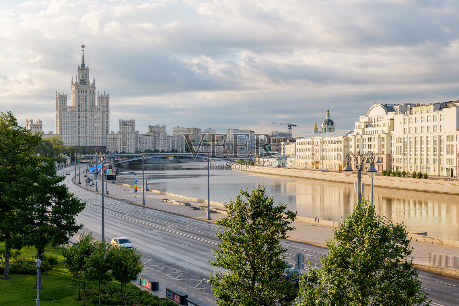 莫斯科宁静的早晨，沿着莫斯科河的空旷道路，柔和的金色光线与标志性的高层建筑天际线相映成趣，营造出宁静而富有电影感的城市氛围。照片摄影图片