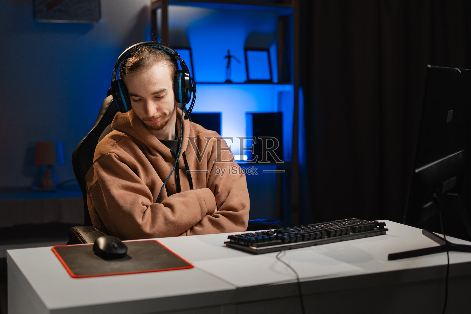 情绪低落的游戏玩家坐在桌前进行直播照片摄影图片