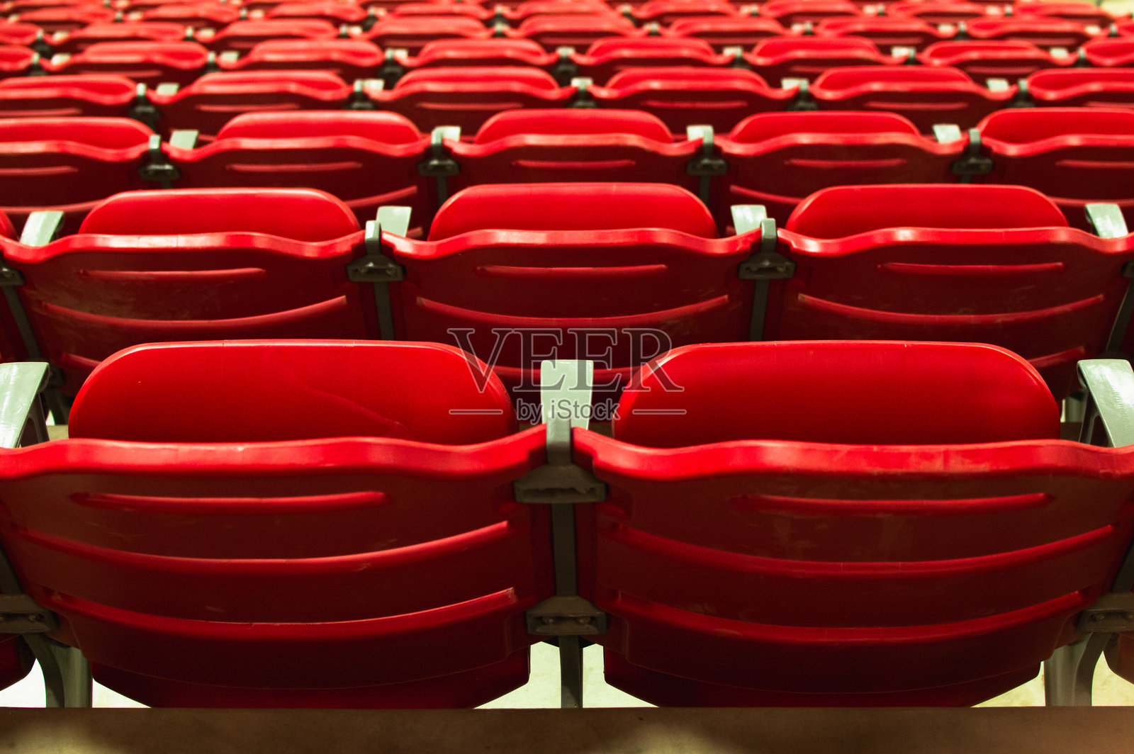 现代室内竞技场中排成行的红色空座位照片摄影图片