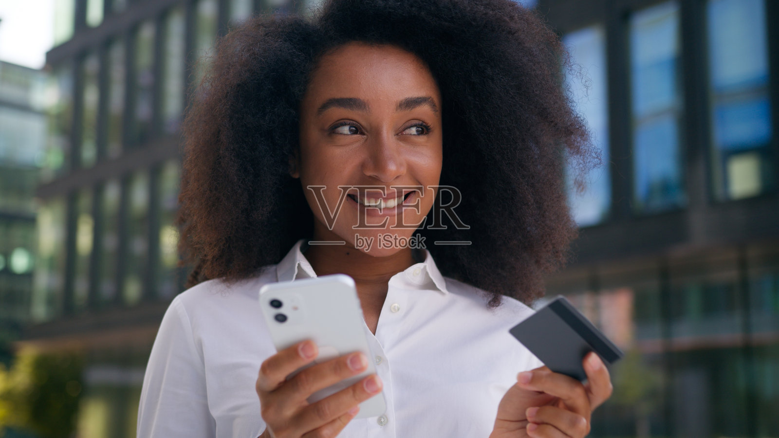 非裔美国女性在户外使用手机进行网上支付，进行金融交易，购物的女商人。照片摄影图片