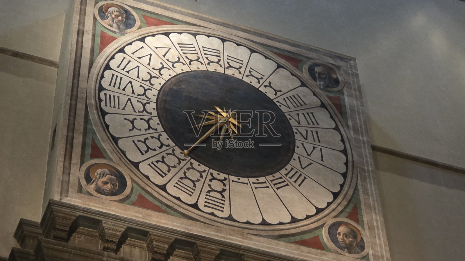 佛罗伦萨大教堂内的24小时礼拜钟，配有罗马数字、金色放射状指针，以及每个角落的四位福音书作者的肖像。照片摄影图片