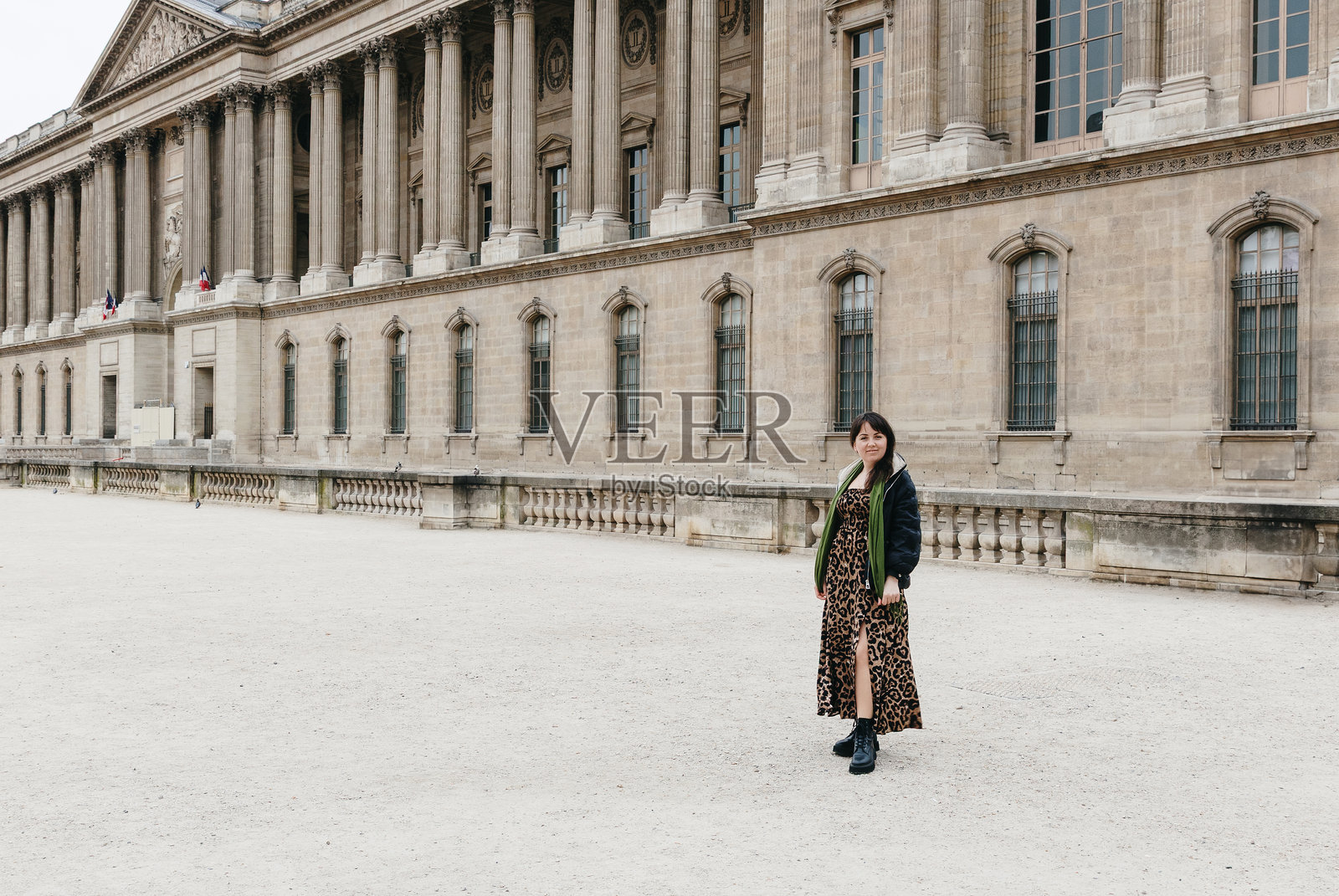 身穿长裙的美丽女孩在城市中摆姿势。照片摄影图片