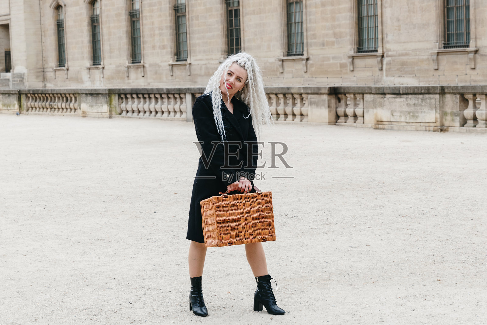 在城市中摆姿势的美丽女孩与野餐篮。照片摄影图片