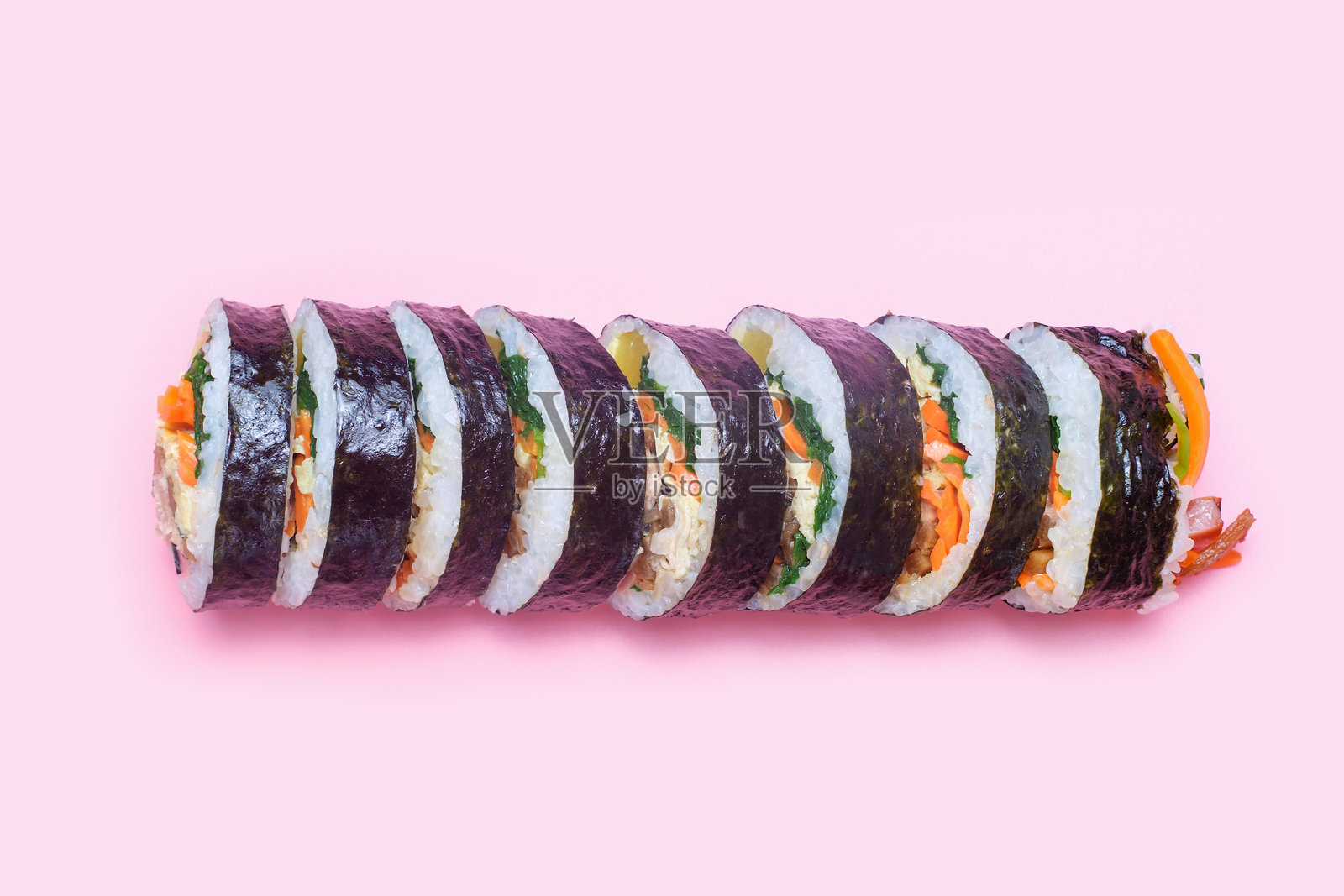 粉色背景上的韩式紫菜包饭卷，俯视图。照片摄影图片