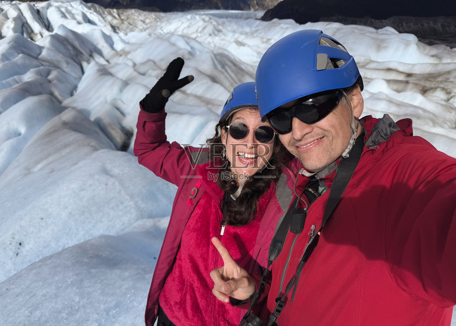 快乐的游客情侣在冰川上自拍照片摄影图片