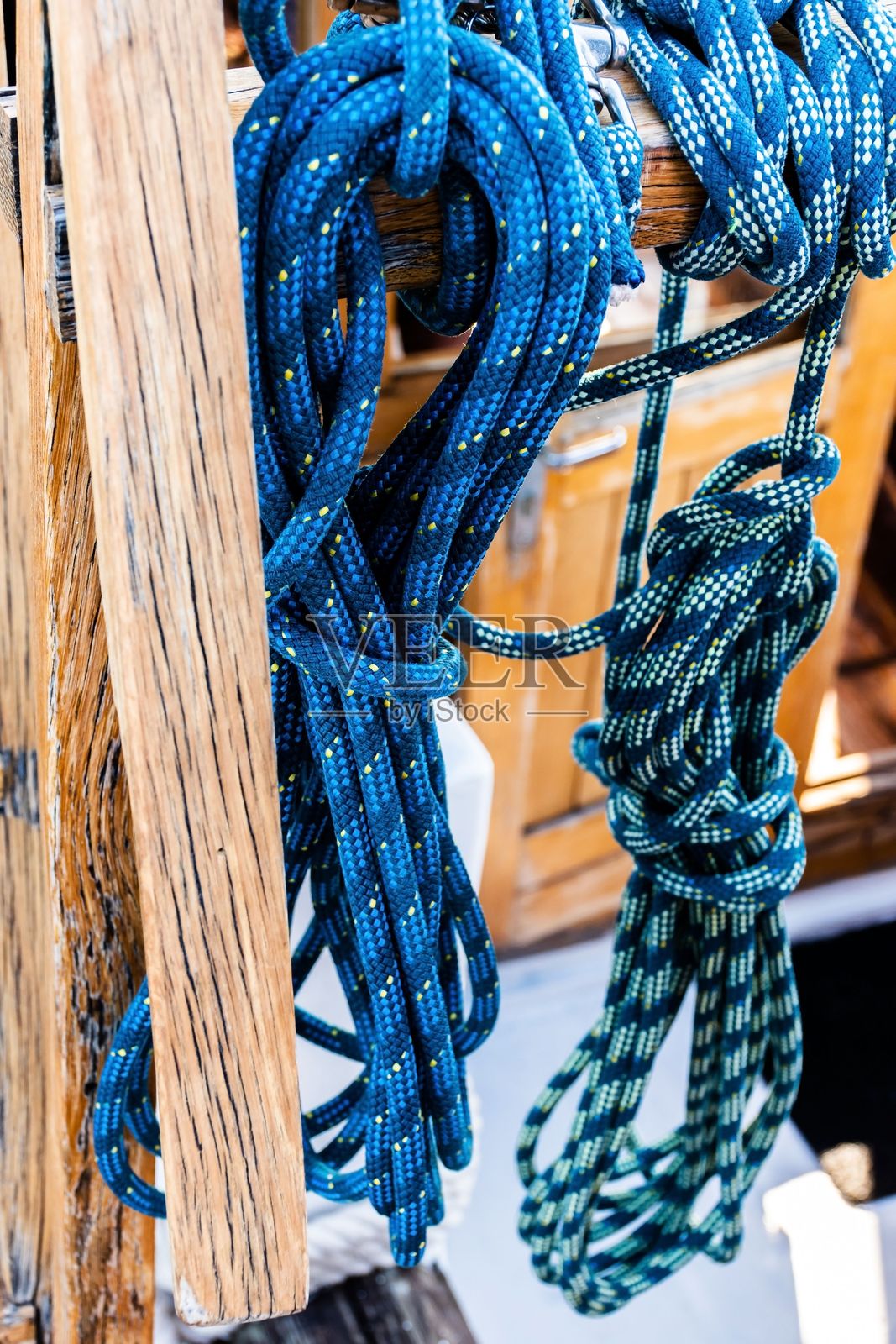一堆绳子挂在木墙上。照片摄影图片