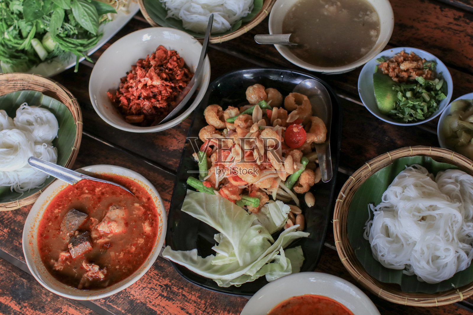 香脆鱼肚配辣味沙拉，黑色盘子里的三味拼盘。泰国菜。餐厅。照片摄影图片