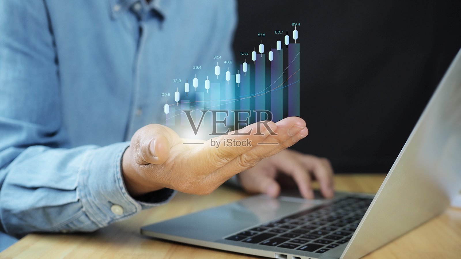 技术投资与价值投资概念。商人手持虚拟技术图表和图形以分析股市。照片摄影图片