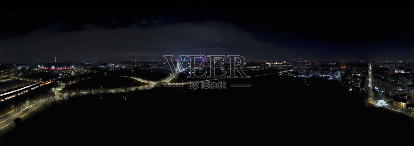 华沙夜景，来自维斯瓦河右岸，PGE国家体育场、维斯瓦桥和闪烁的城市灯光。照片摄影图片