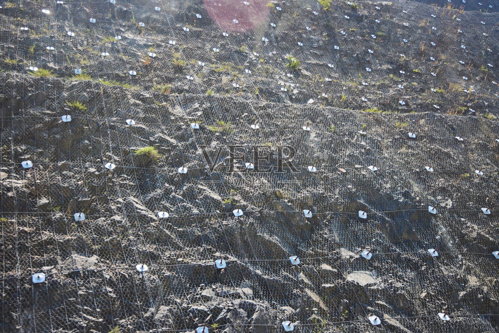 山坡加固网格。防止滑坡和破坏。照片摄影图片