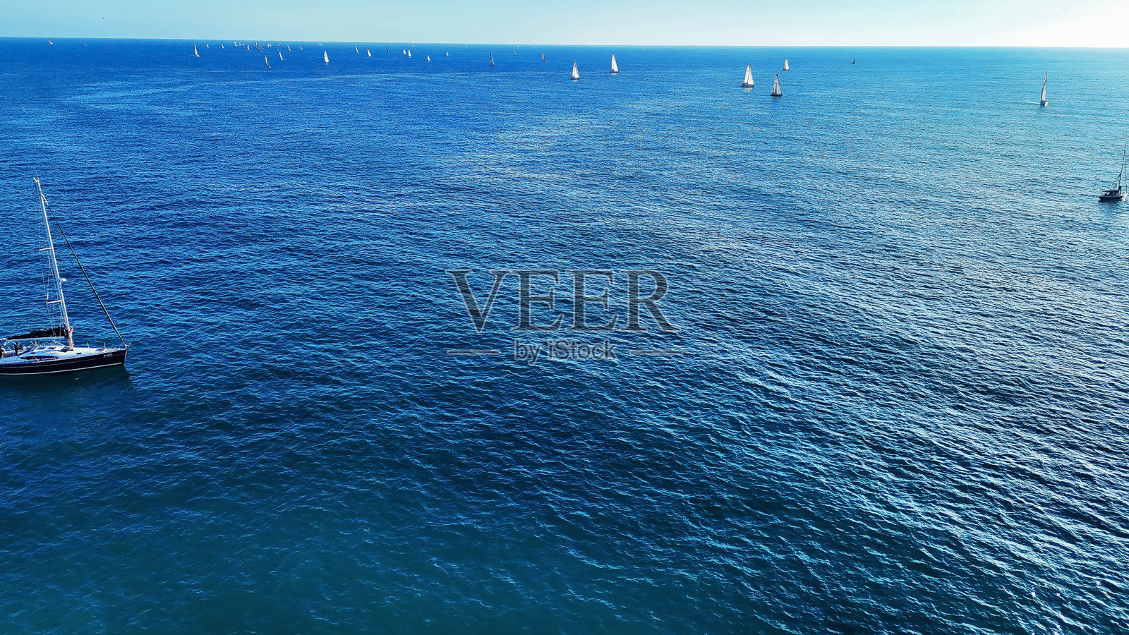 在宁静的下午，蔚蓝的天空下，平静的水面上进行一场宁静的航海冒险照片摄影图片