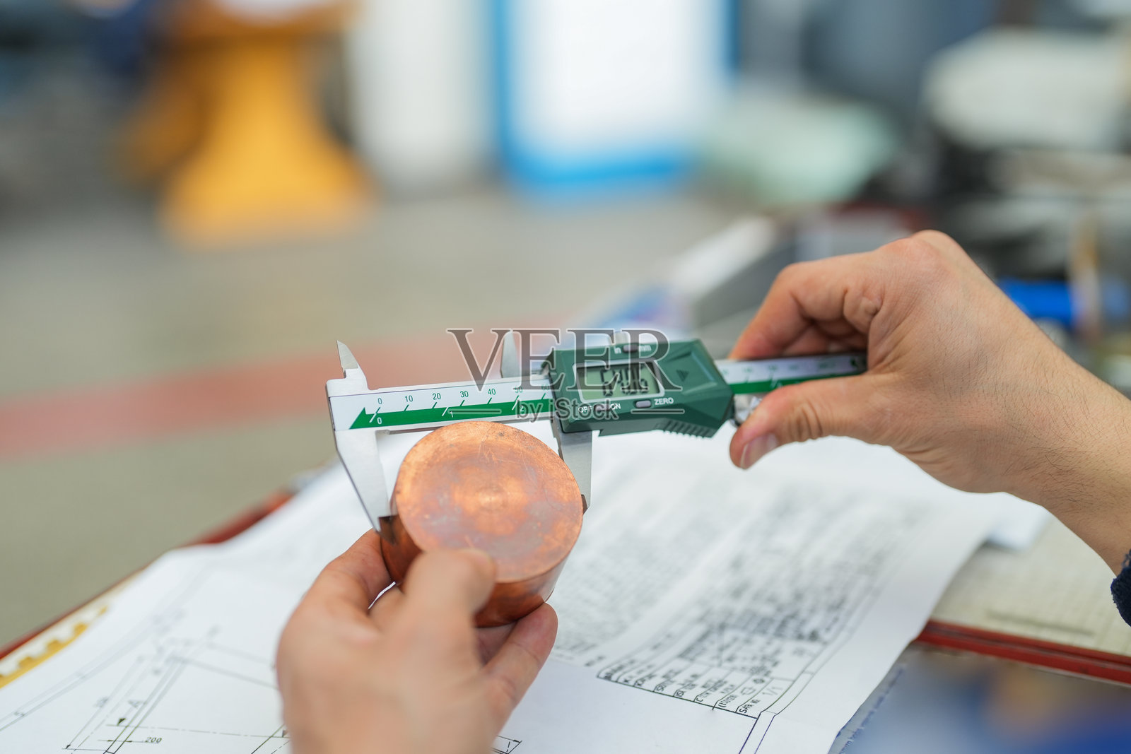 技术人员使用卡尺测量零件的特写，零件和技术图纸清晰可见照片摄影图片