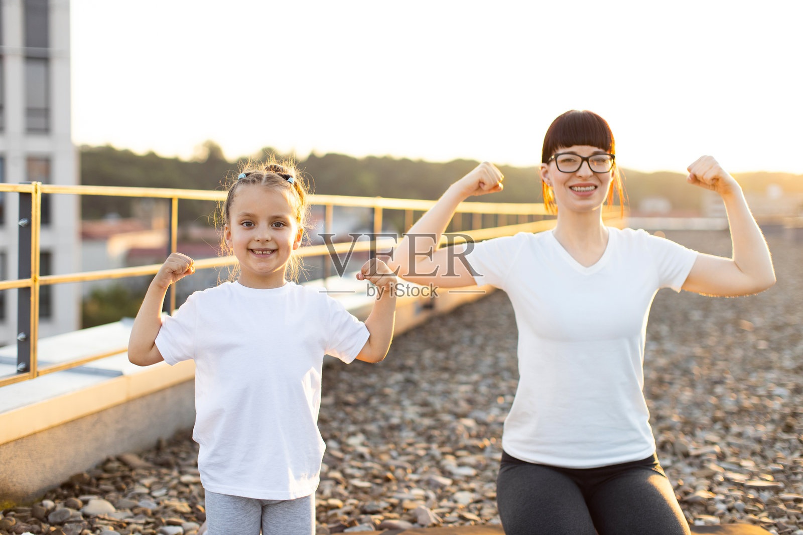 母女在黄金时刻户外展示肌肉照片摄影图片