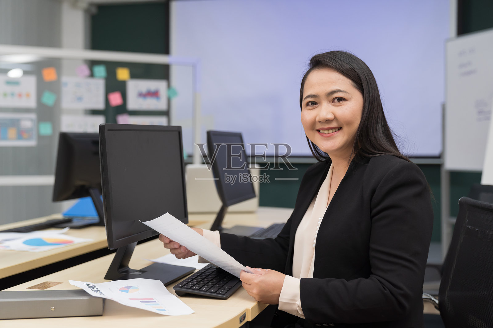 办公室，女商人在桌子上使用电脑工作。女商人或企业家在办公室快乐地工作。企业、员工和专业人士在公司工作场所。照片摄影图片