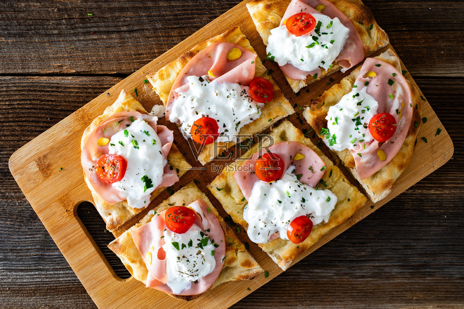 罗马风味的比萨，上面有意大利火腿、布拉塔奶酪和开心果，放在木桌上照片摄影图片